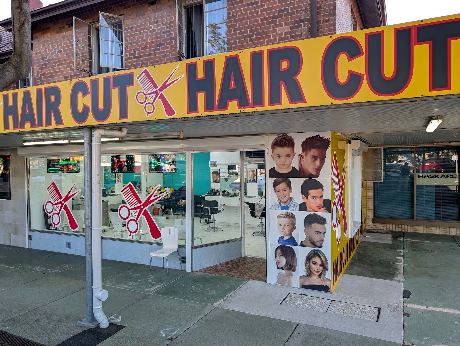 A barber cutting a client’s hair in a bright white salon
